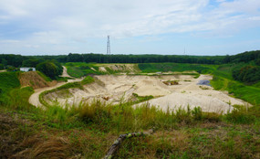 A sand pit among tall green grasses
