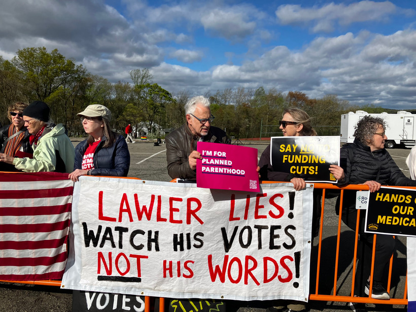 Protesters outside Clarkstown South High School in West Nyack on April 27 say they don't trust Rep. Mike Lawler's promise to protect Medicaid recipients.