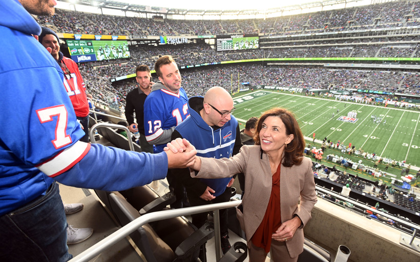 New York Governor Kathy Hochul shakes hands with someone in a Buffalo Bills uniform at Metlife Stadium in New Jersey.