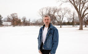 James Pugh stands in a stark field covered with snow.