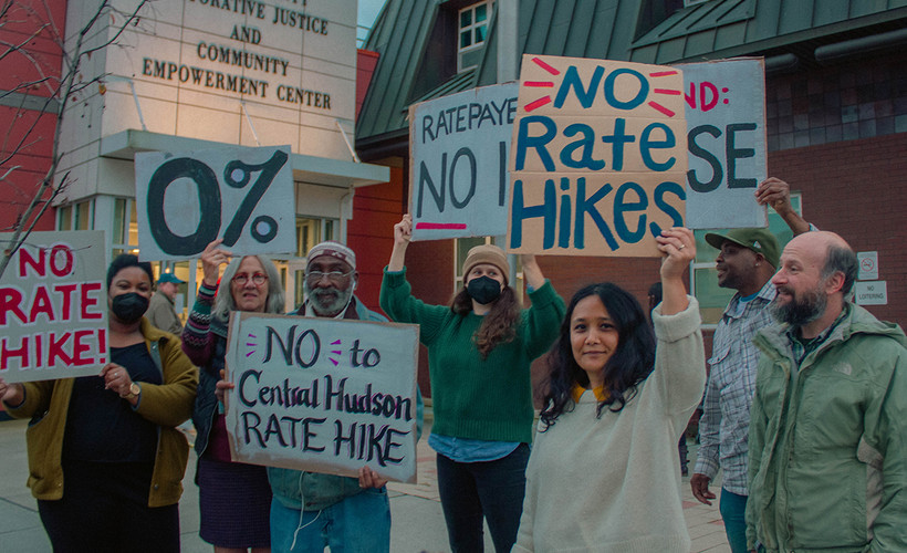 A group of people with signed saying "no rate hikes"