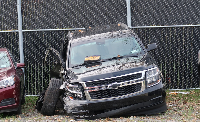 A car with the right side destroyed sits in a lot.