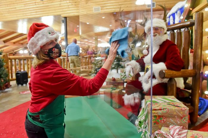 Una trabajadora de Cabela’s de Tilden Township, Pensilvania, limpia plexiglás entre Santa y los visitantes al centro comercial en noviembre de 2020.