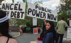 Sarahana Shrestha holding a sign that says "Public Power Now"