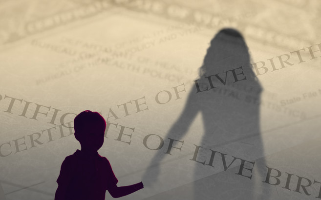 A child silhouetted in the foreground holds hands with an adult, who is separated from the child by a transparent layer composed of birth certificate paperwork.