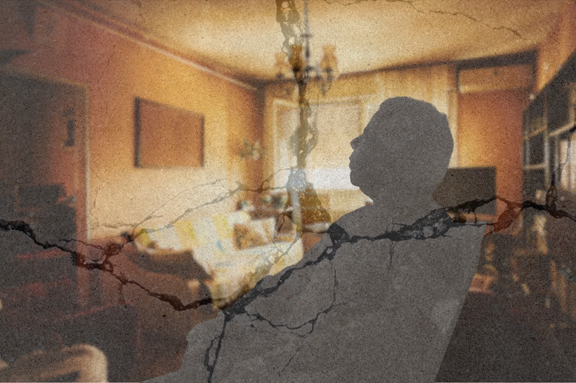 A silhouette of an elderly person sitting alone in a chair in a warm living room. Cracks appear over the image, indicating precarity.