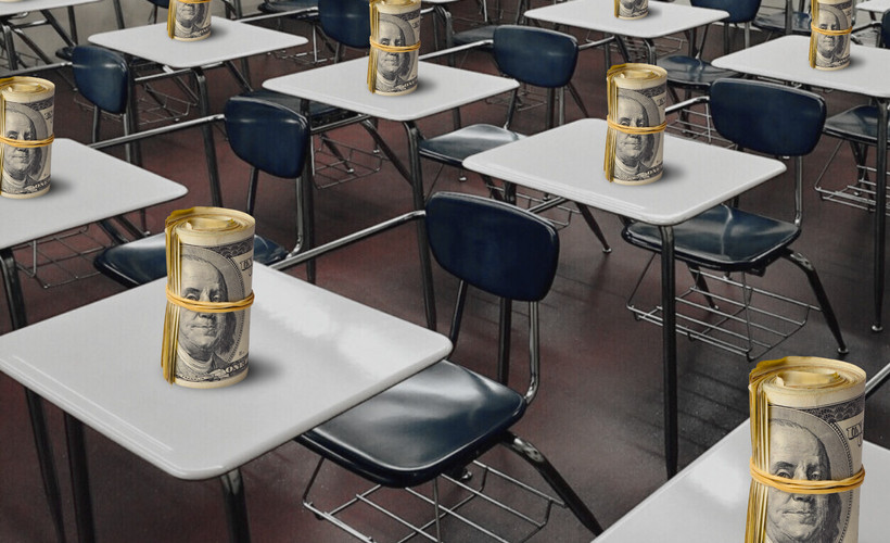 Rows of desks in a classroom with a roll of dollar bills on each desk.